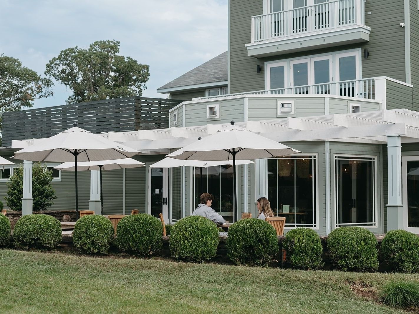 Couple dining under umbrellas on a patio at Early Summer Reset.