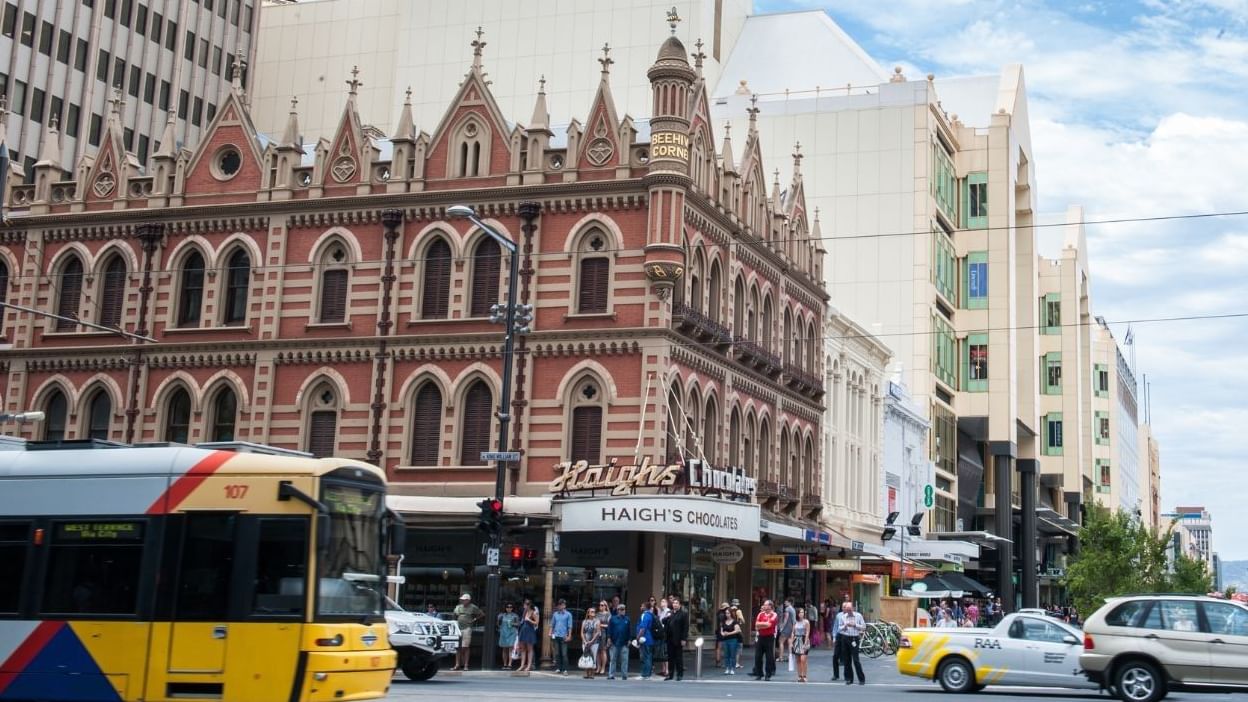 Busy street intersection in Adelaide CBD with historic buildings nearby.