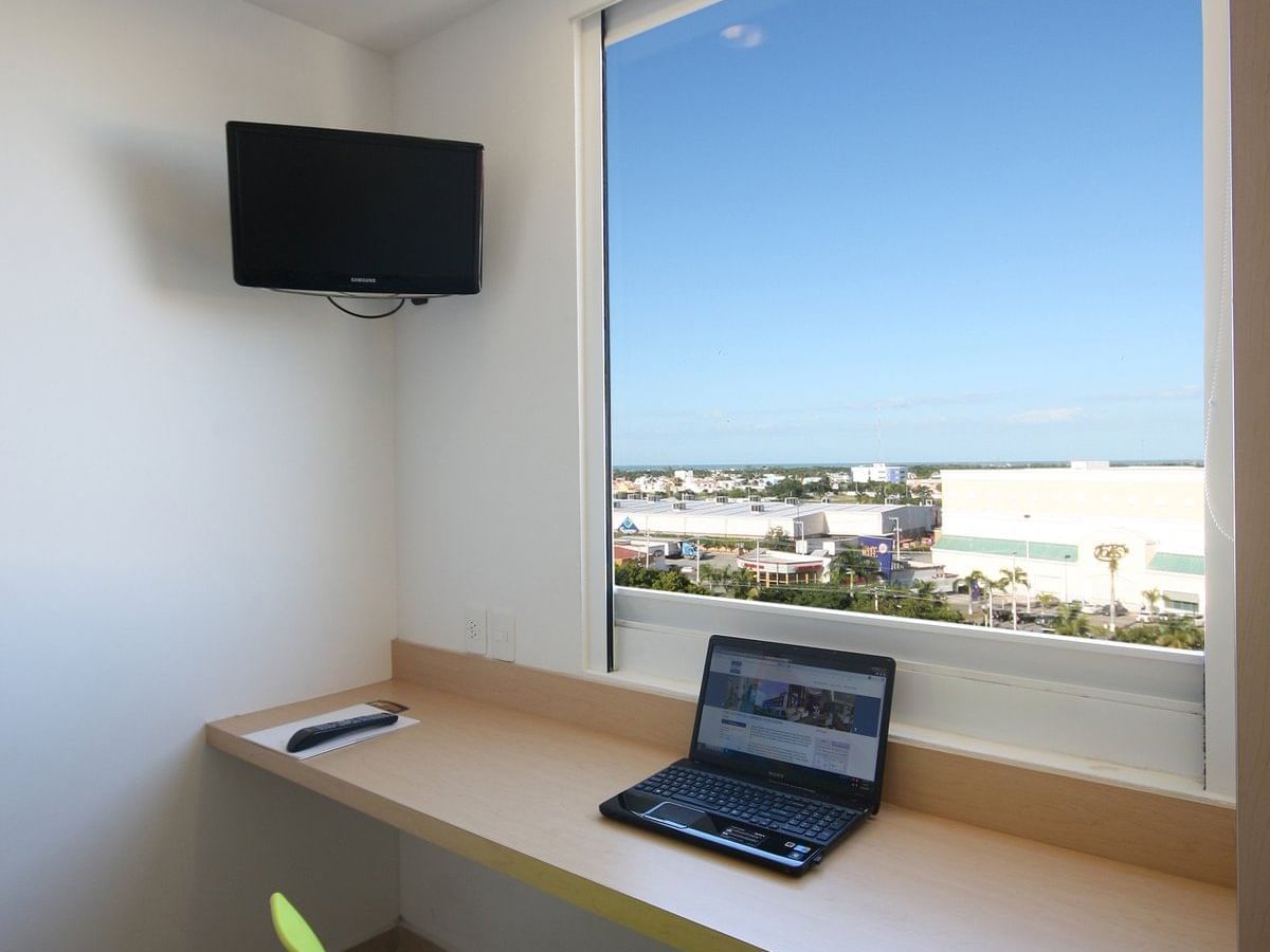 Laptop on a Wall-mounted desk by a window at One Hotels