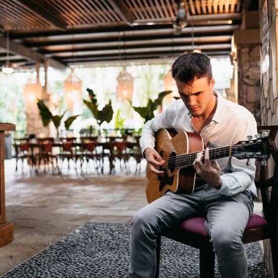 Man playing guitar at Pullman Palm Cove Sea Temple Resort & Spa