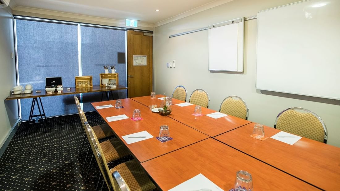 Boardrooms 1, 2 and 3 featuring a large wooden table set with  whiteboards at Mercure Hotel Townsville