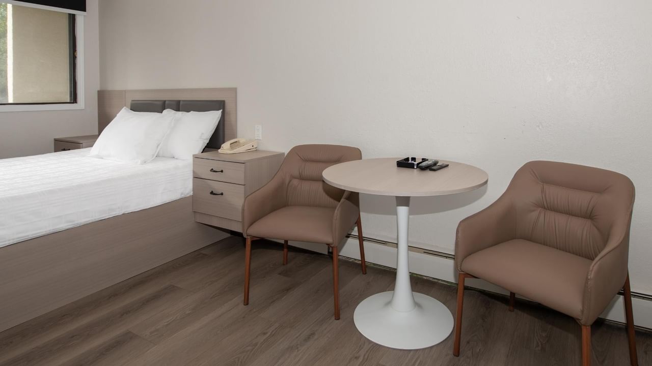 Guest room at Coast Red Deer Hotel with queen bed and seating area