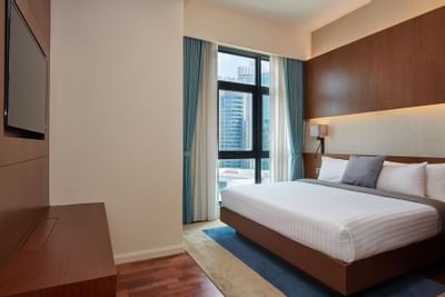 Queen bed with a TV in Duo Suite at Tribeca Serviced Suites