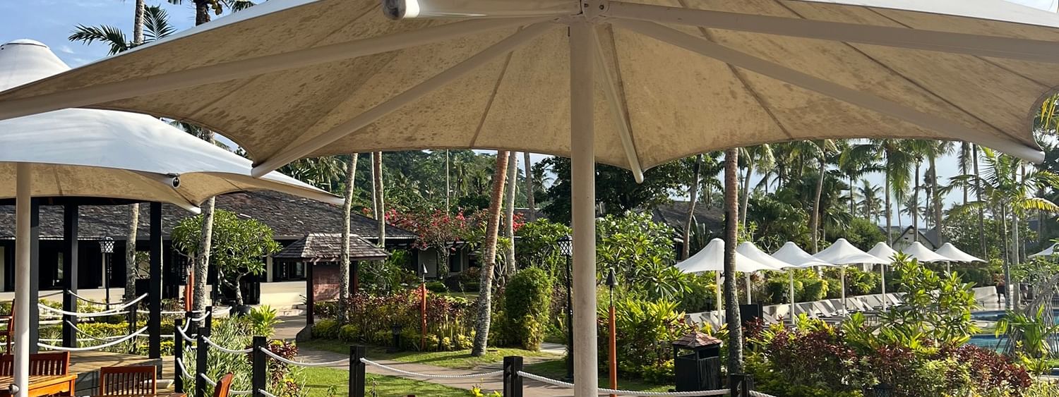 Outdoor dining area under large umbrellas at Lagoon Terrace Restaurant, Warwick Le Lagon - Vanuatu, Efate