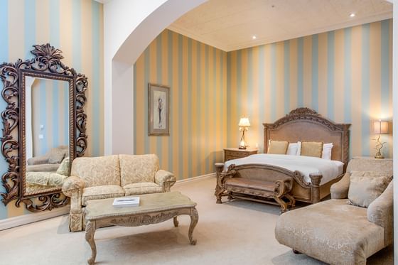 Large bed, comfy sofas & mirror in King Executive King William Room at Retro Suite Hotel