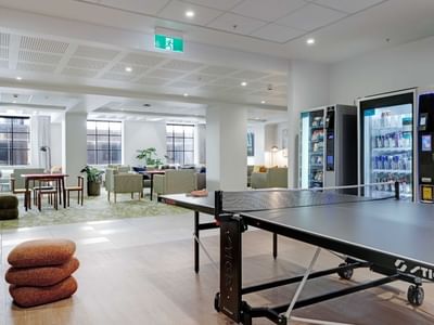 Modern communal lounge with ping pong table, vending machines, and seating areas at UniLodge Auckland Central.