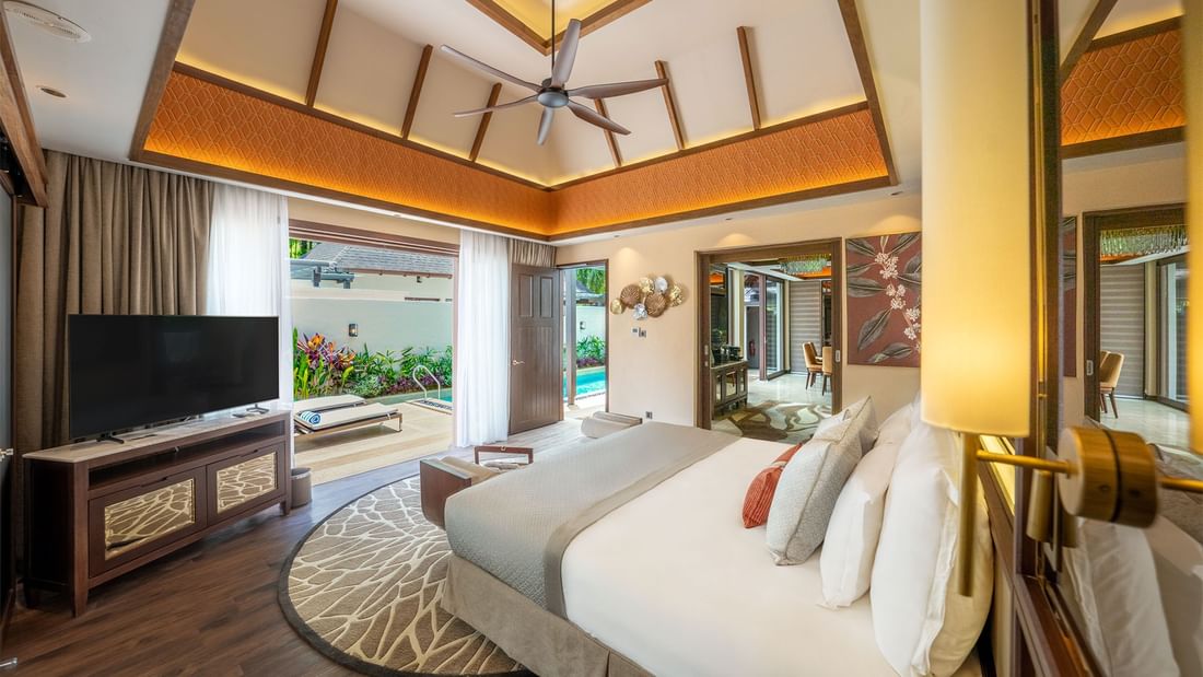 Luxurious villa with large bed, TV, ceiling fan, and access to a private pool promoting ultra-luxury festive stay package