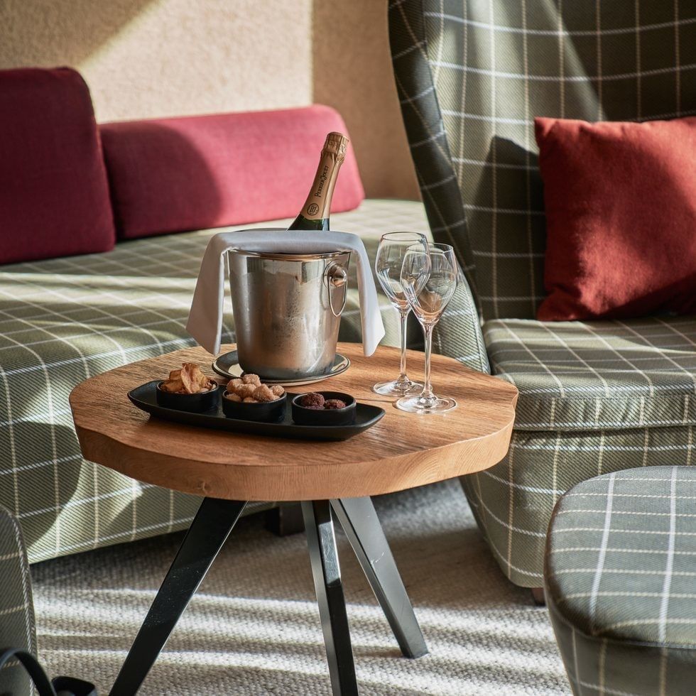 Offerta speciale di metà settimana del 10% con champagne e snack su un tavolo in una sala lounge.
