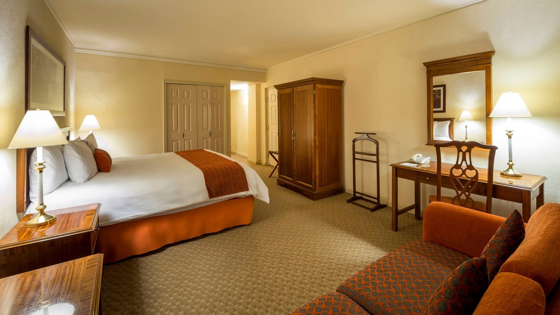 King Camino Real Club with a wooden armoire, work desk, and patterned rug at Camino Real Puebla Angelopolis