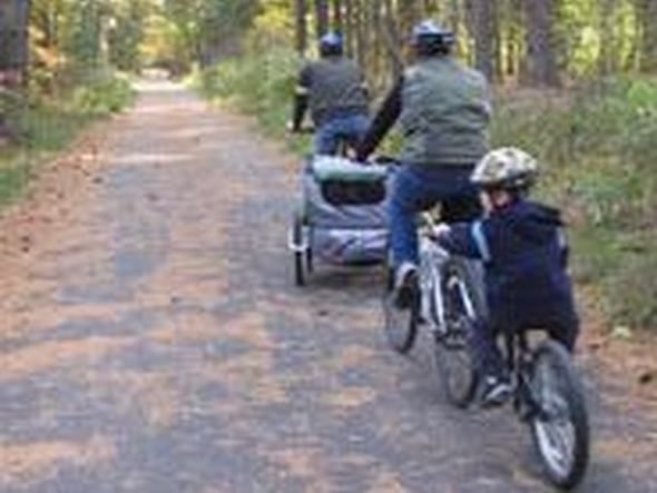 Family riding bicycles in Bruce Freeman Rail Trail near Westford Regency