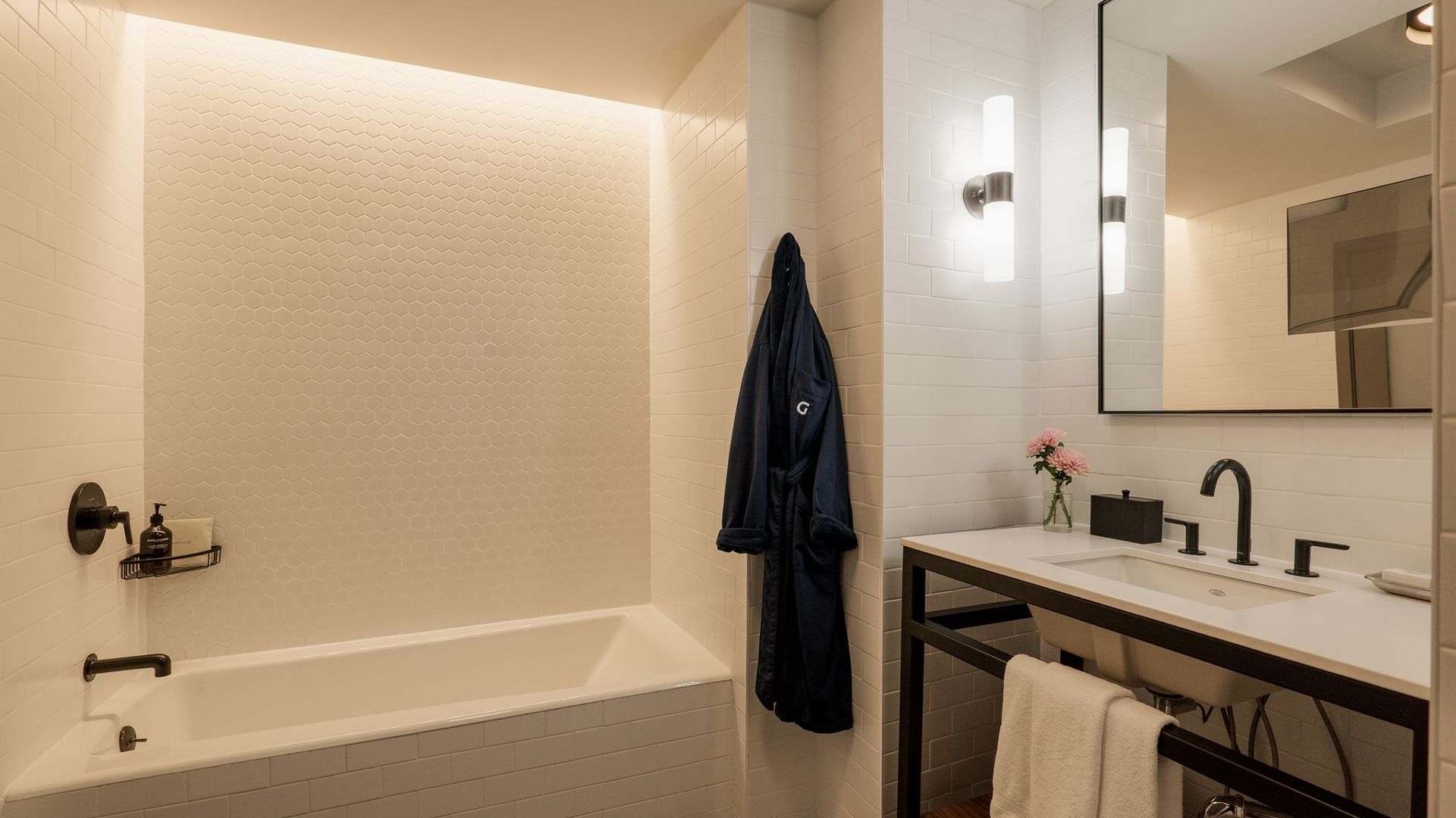 Modern bathroom with white subway tile, soaking tub, and double vanity in Two-Bedroom Manhattan Suite at Gansevoort Meatpacking NYC