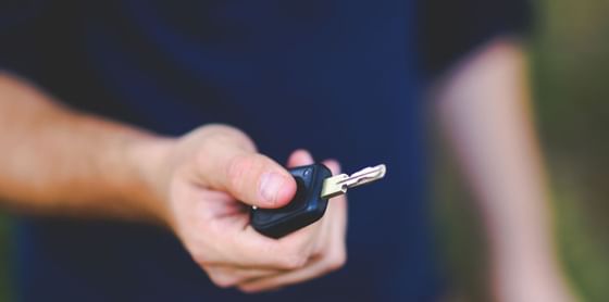 Close up on a man holding a key of a car at Vasa Hotel Surabaya