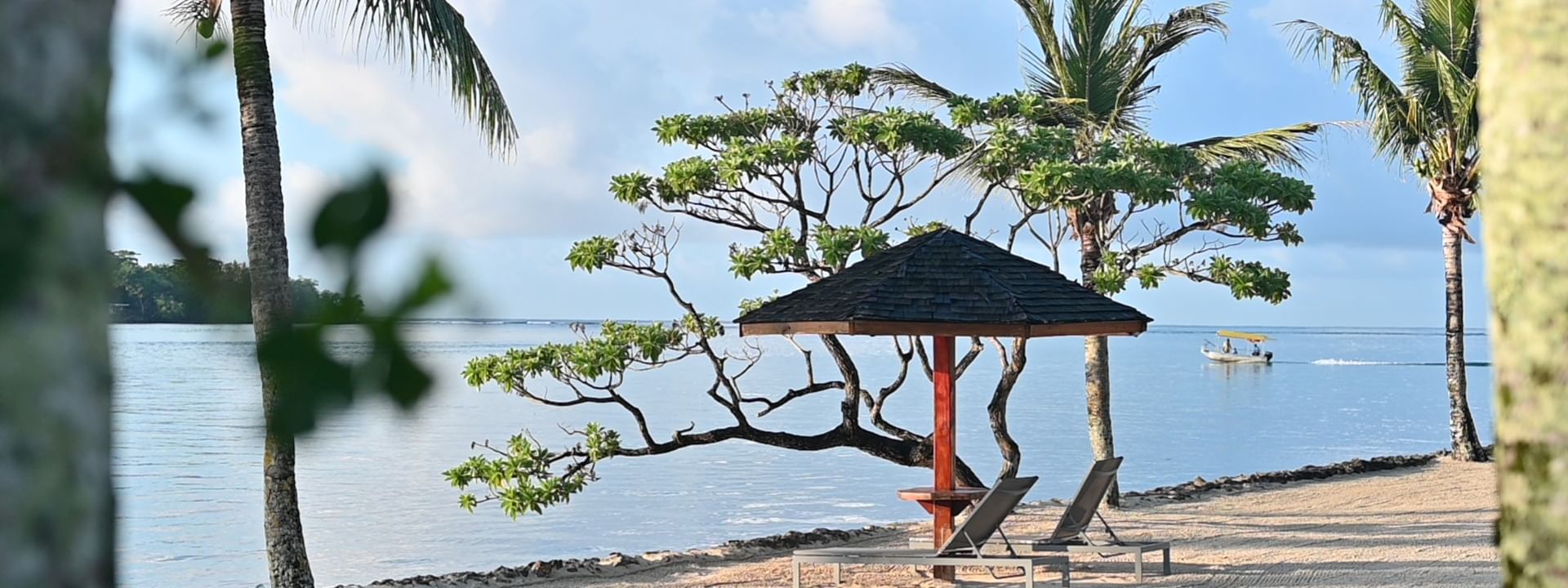 Beach loungers under a shaded umbrella at Warwick Le Lagon - Vanuatu in Efate