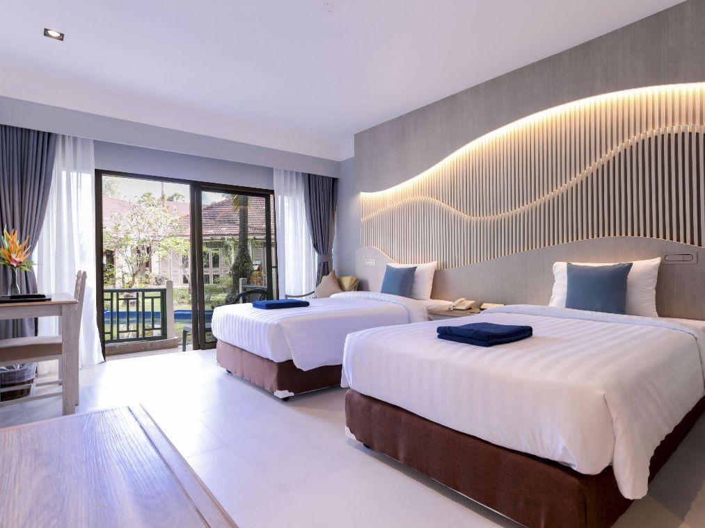 Two beds, working desk with garden view at Amora Hotel