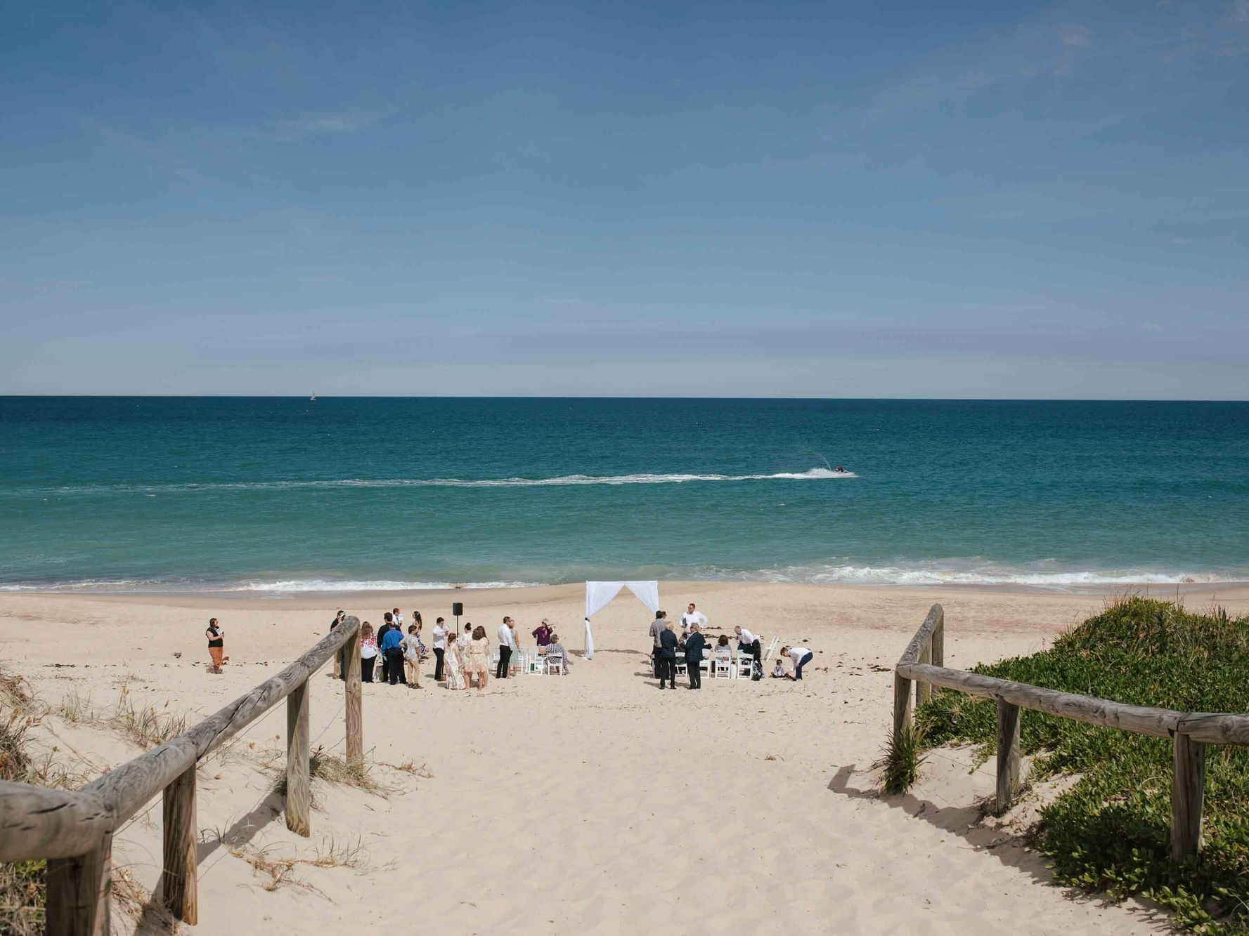 People gathered for Beach wedding ceremony near Pullman Magenta Shores