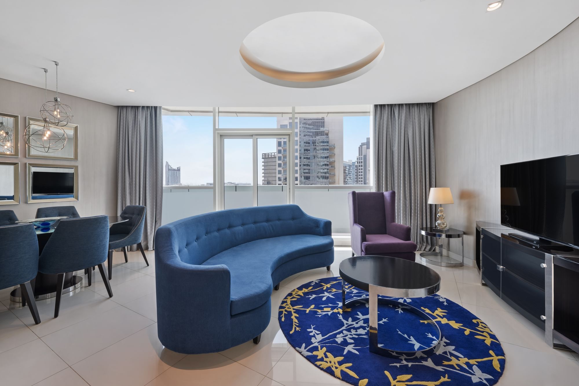 Dining table by TV lounge area in Three Bedroom Suite at DAMAC Maison Distinction, a suite hotel in Dubai