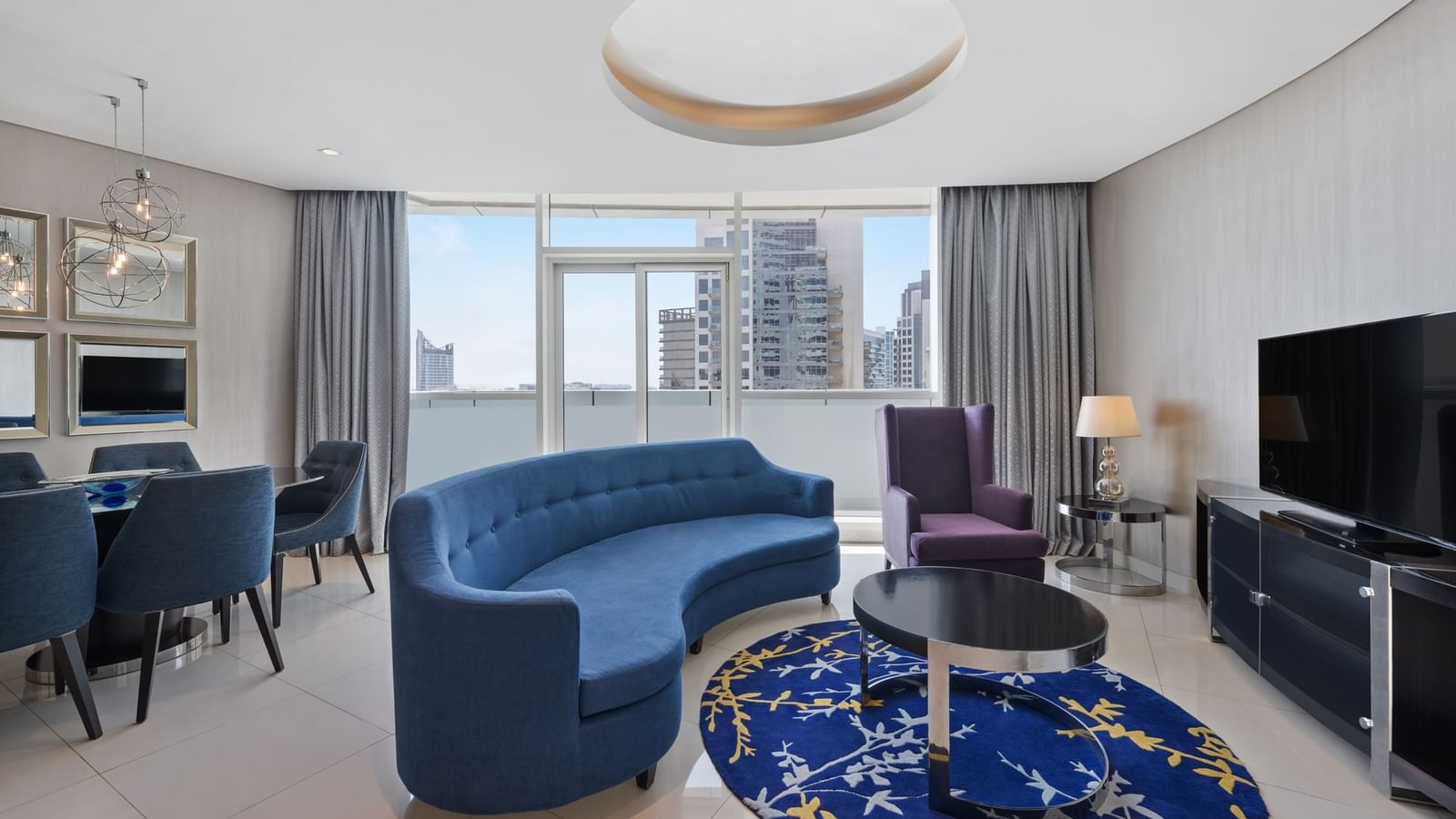 Dining table by TV lounge area in Three Bedroom Suite at DAMAC Maison Distinction, a suite hotel in Dubai