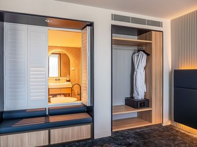 Bravo Suite featuring a bathroom view through shuttered doors, a robe hanging in a wooden closet at Encore By Mingara