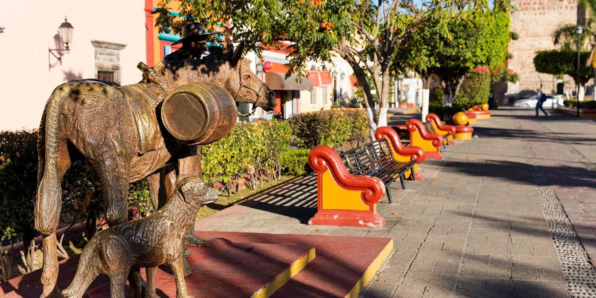 Estatuas con zona de asientos dispuestas en una acera cerca de One Hotels