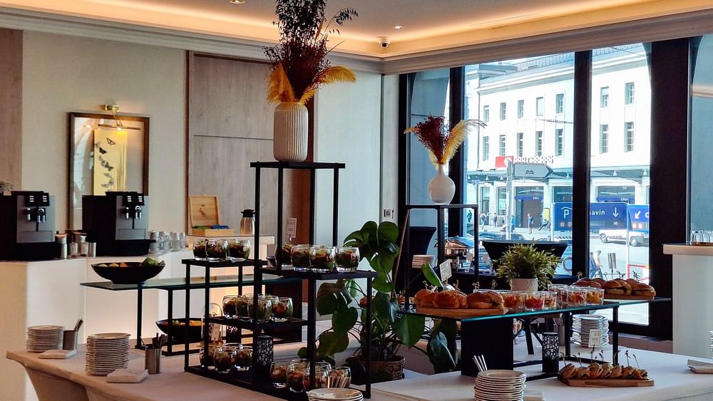 Appetizer cups by sliders on tiered glass stands under tall floral vases in Foyer Mezzanine at Warwick Geneva