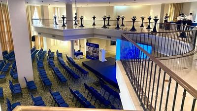 Colombia Meeting Room featuring rows of chairs, a podium onstage, and a balcony above at Dann Carlton Cali