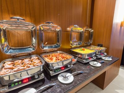A buffet display with various dishes served in Breakfast in the Loft at Matrix Hotel