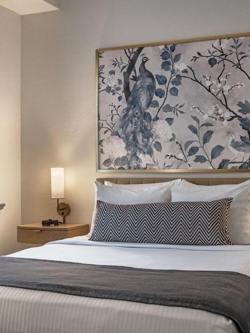 Bed with side tables under hanging wall art in Standard Room at Warwick Allerton Chicago