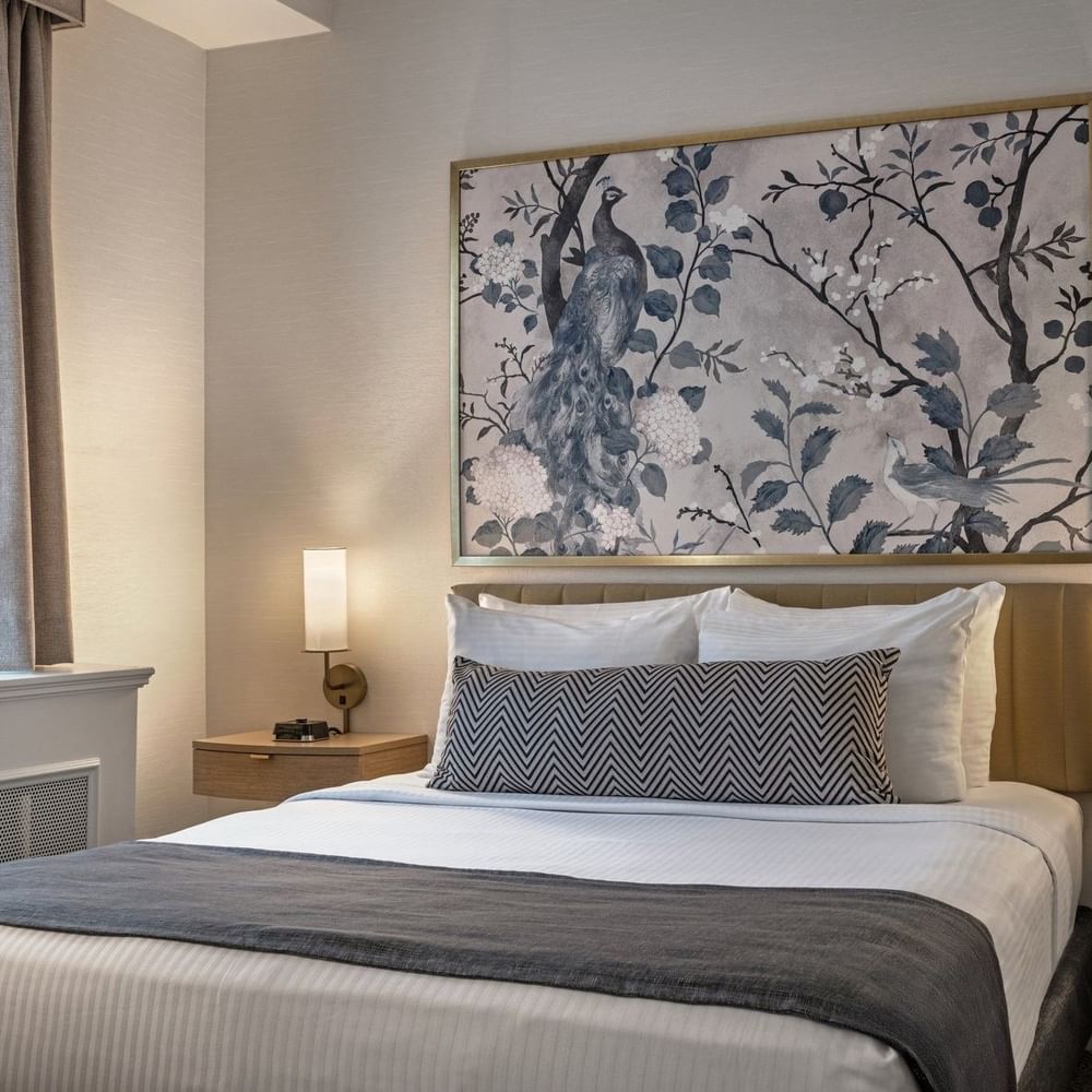 Standard Room with a large bed, decorative wall art, and nightstands at Warwick Allerton Chicago.