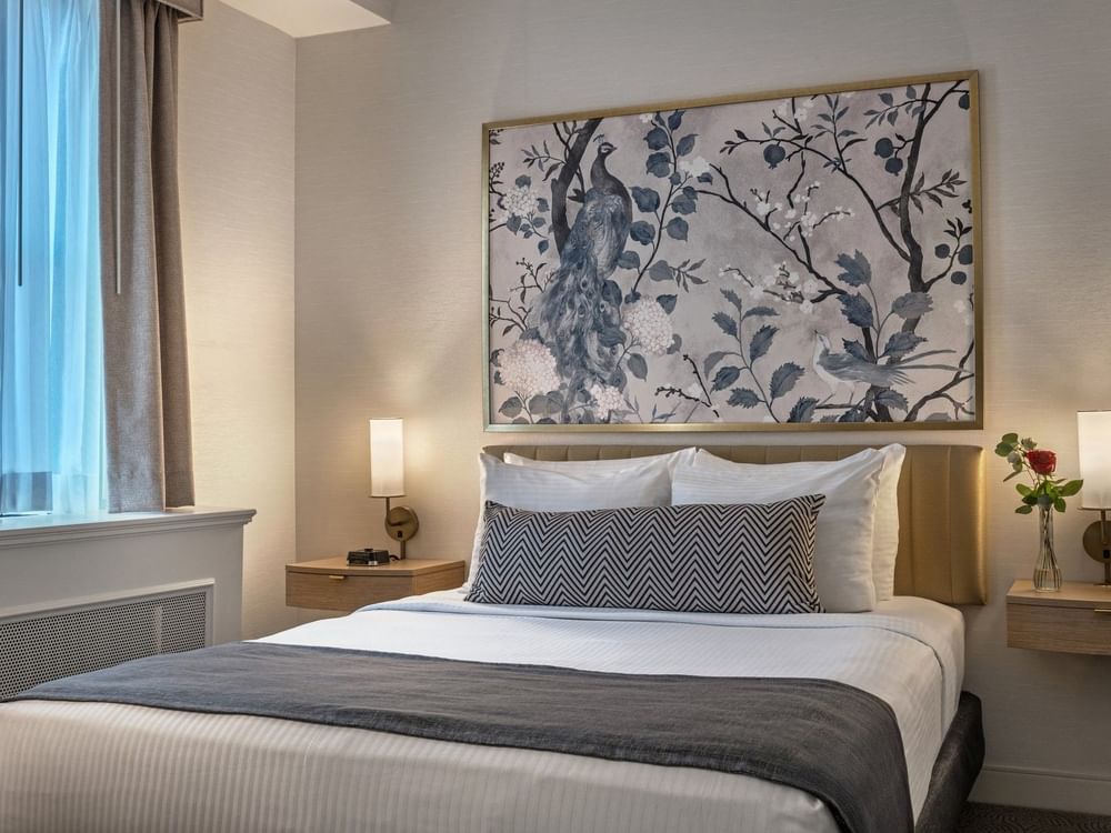 Bed with side tables under hanging wall art in Standard Room at Warwick Allerton Chicago