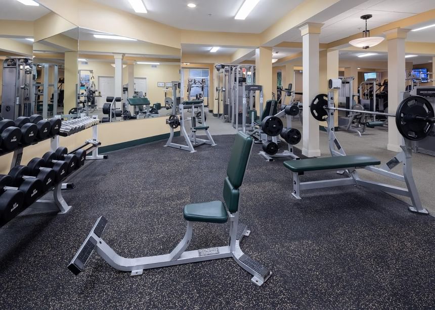 Benches, dumbbell rack & fitness training equipment in Ogunquit Fitness Center at Meadowmere Resort with spacious interior