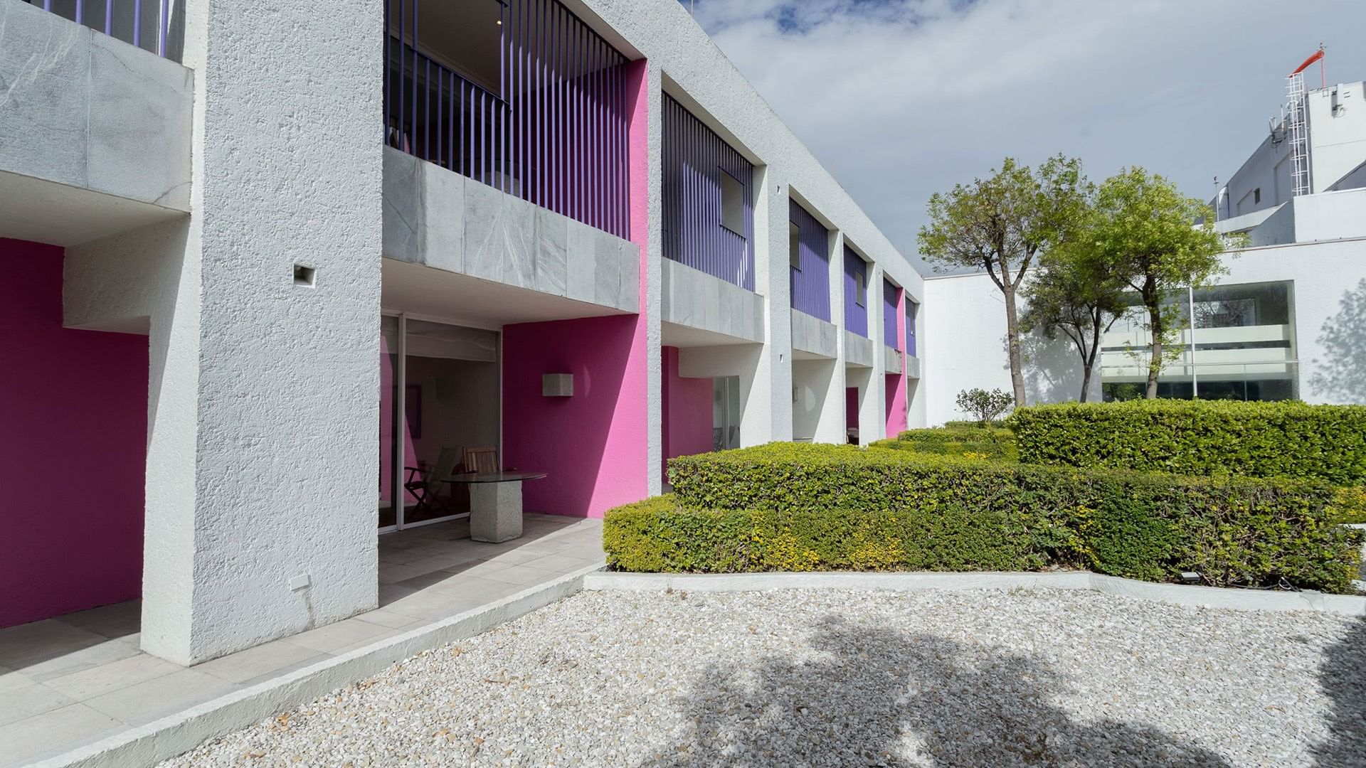 Architectural exterior in King Viceroys Suite with bold pink accents and lush green hedges at Camino Real Polanco Mexico