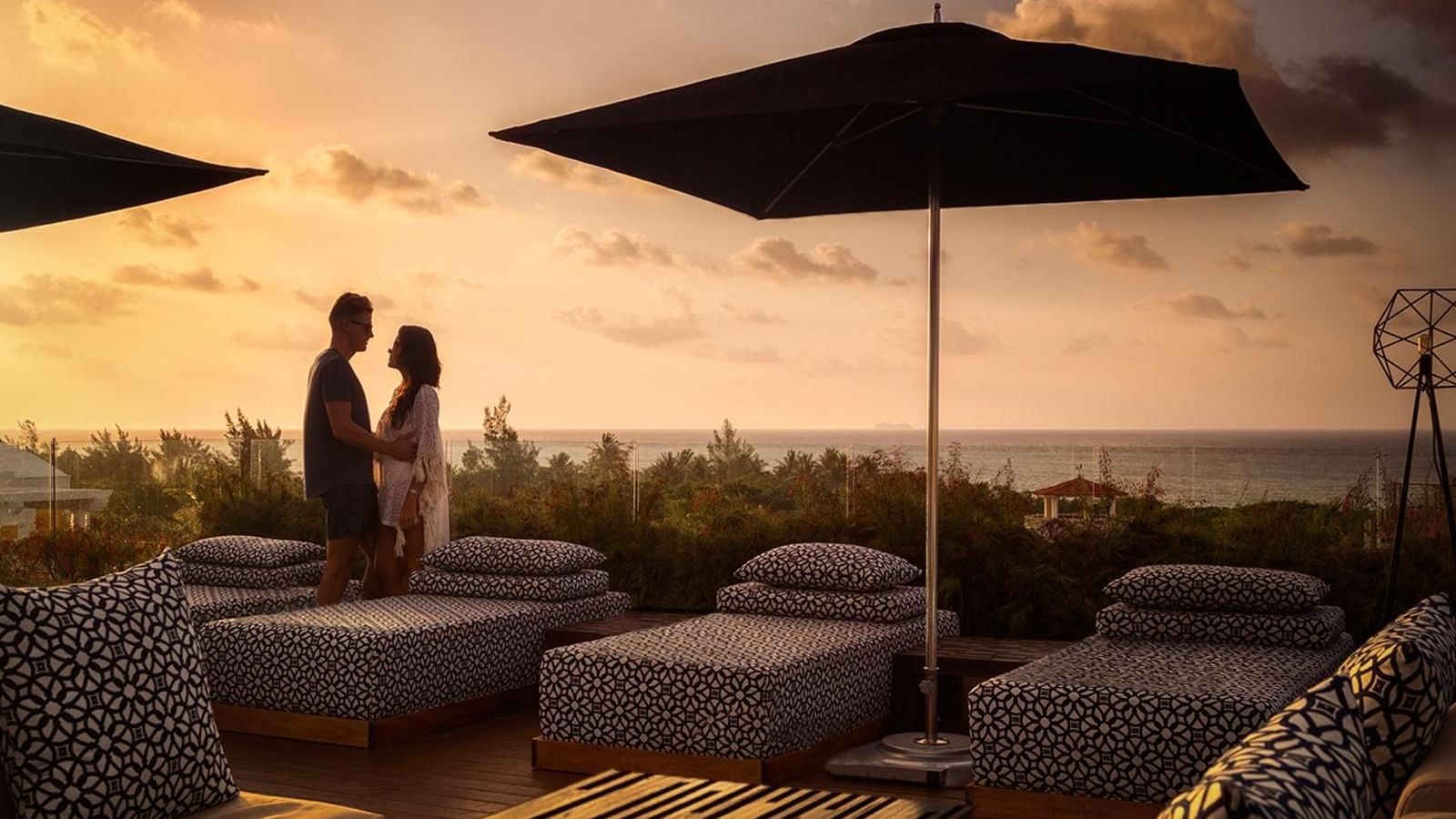 A couple standing by lounge beds at Grand Fiesta Americana