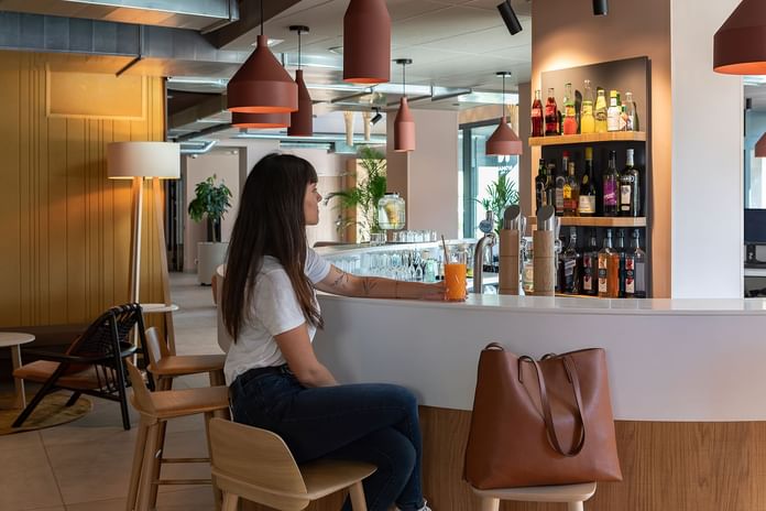 Lady enjoying her drink by the Bar counter in Dijon Bar at Oceania Hotels