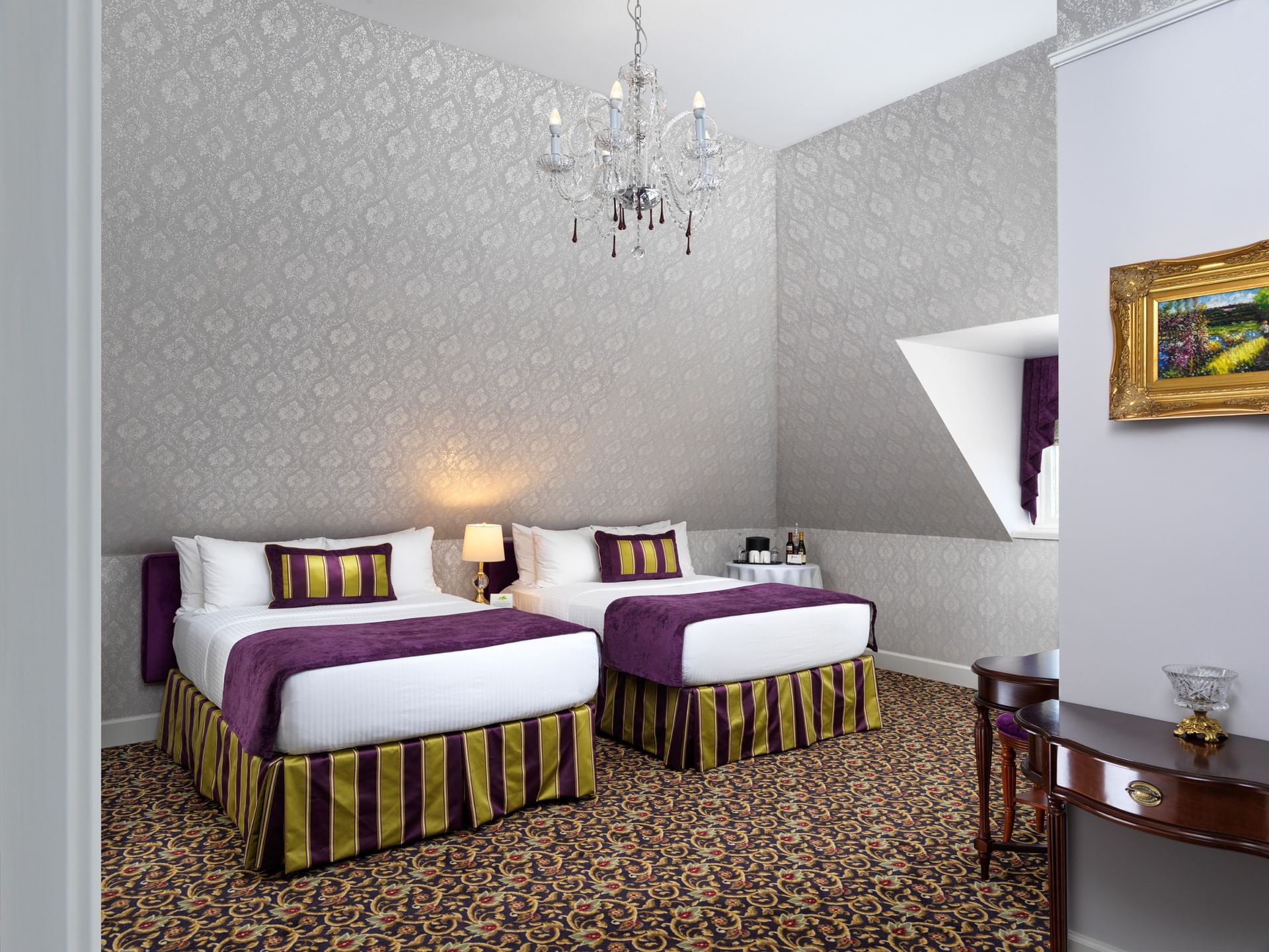Two double beds and a chandelier in Amelia Jane Room at Pendray Inn & Tea House
