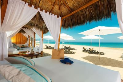 Beach cabana with drapes, sun loungers, and umbrellas on beach near Villa Premiere Boutique Hotel & Romantic Getaway
