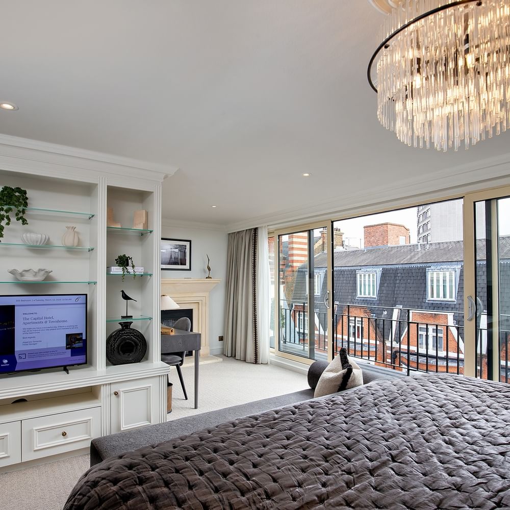 Elegant penthouse bedroom with large bed and city view at The Capital Hotel, Apartments & Townhouse - London.