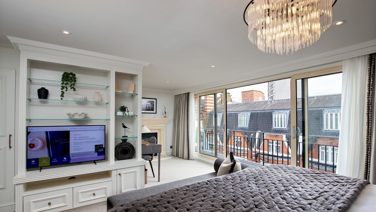 Elegant penthouse bedroom with large bed and city view at The Capital Hotel, Apartments & Townhouse - London.