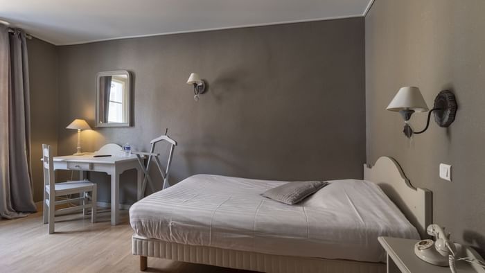 Double bedroom with a wooden writing desk at Hotel de la bal.