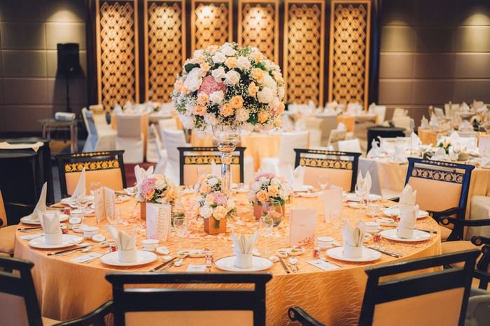 Elegantly set round table for a banquet at One World Hotel, featuring a large floral centerpiece and fine place settings