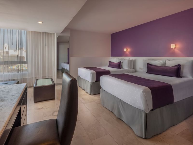 Two cozy beds and working area of Junior Suite Double at Gamma Hotels