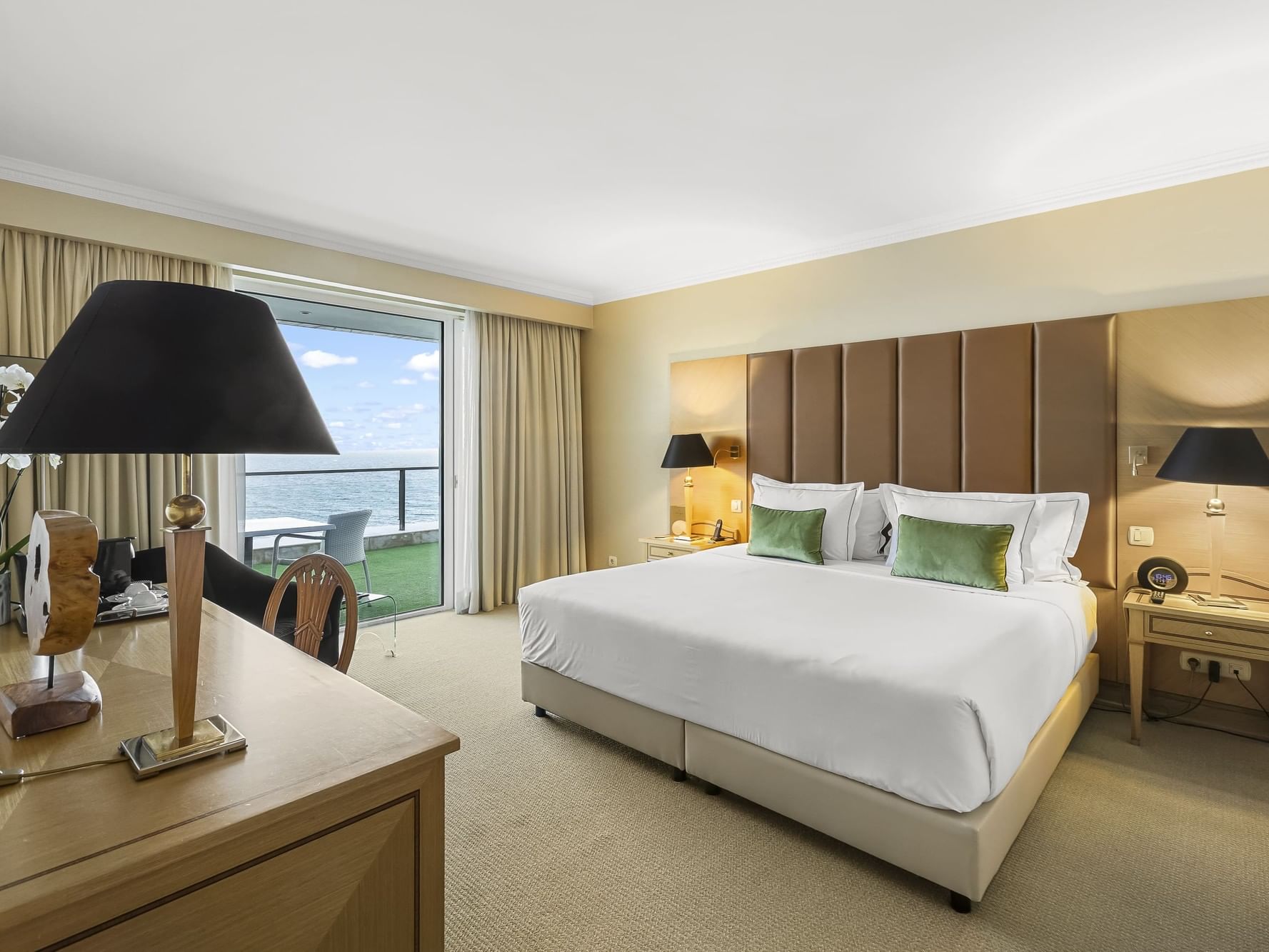 Habitación elegante con cama grande, vistas al mar y decoración moderna en vacaciones de primavera en Cascais.