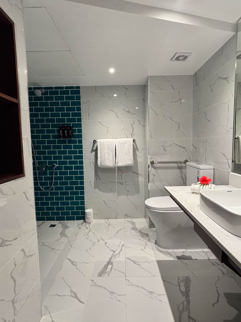 Modern bathroom with white fixtures and blue tiles in the Garden View Rooms at Warwick Fiji Resort and Spa, Korolevu.