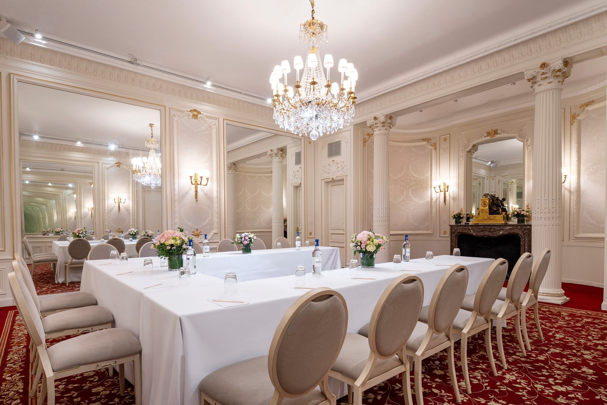 U-shaped table set up with chairs under the crystal chandelier at Hotel Westminster Paris