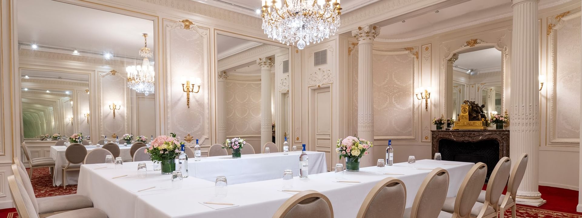U-shaped table set up with chairs under the crystal chandelier at Hotel Westminster Paris