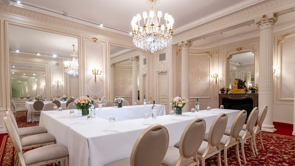 U-shaped table set up with chairs under the crystal chandelier at Hotel Westminster Paris