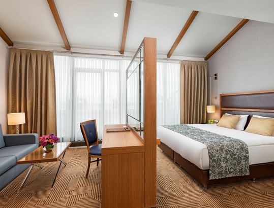 TV lobby area with comfy bed & leather sofa in Executive Room at Titanic City Taksim