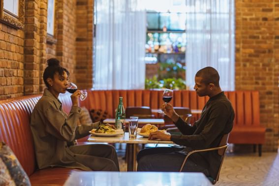 A couple enjoying their breakfast and their glass of wine
