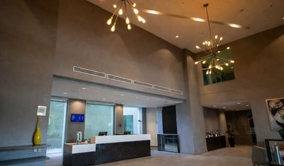 High-ceiling lobby with starburst chandeliers & reception at Hotel Mirra, a hotel near us border crossing, San Luis, Sonora