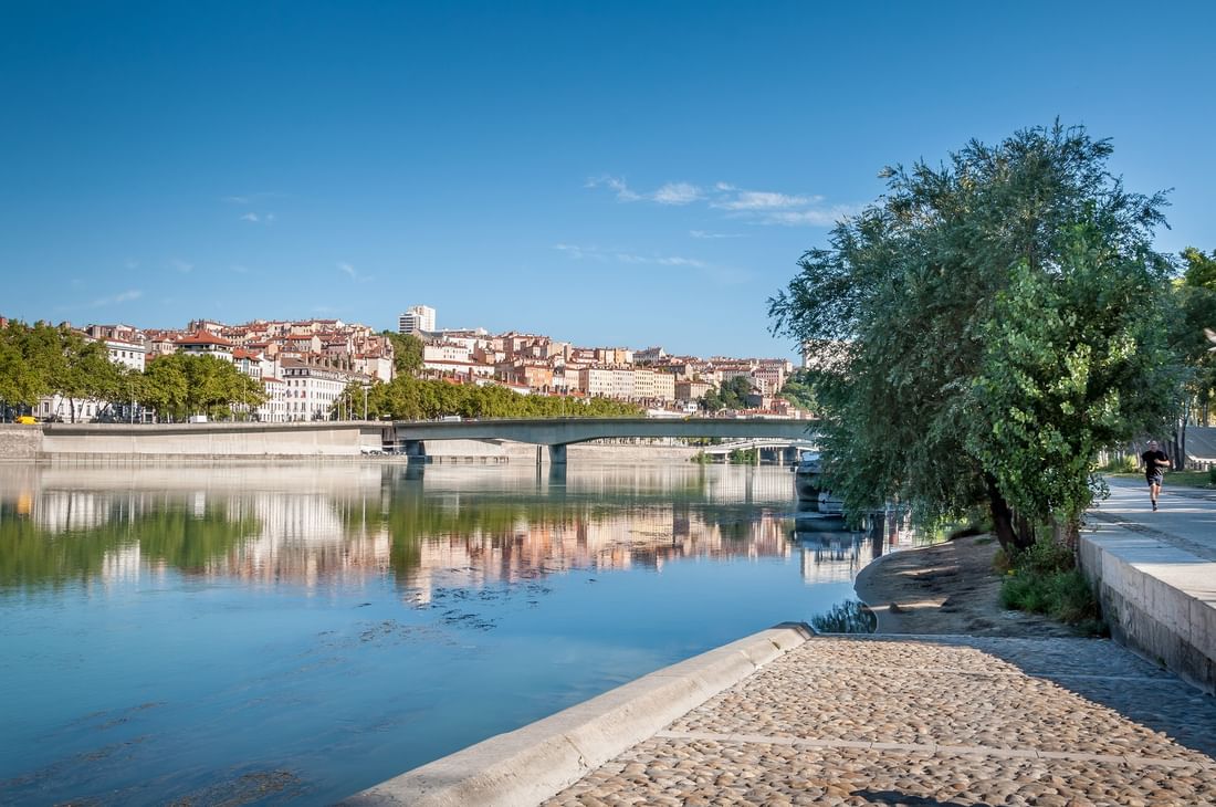 Scenic view of the Saône river and city bridges under a blue sky at Warwick Reine Astrid - Lyon