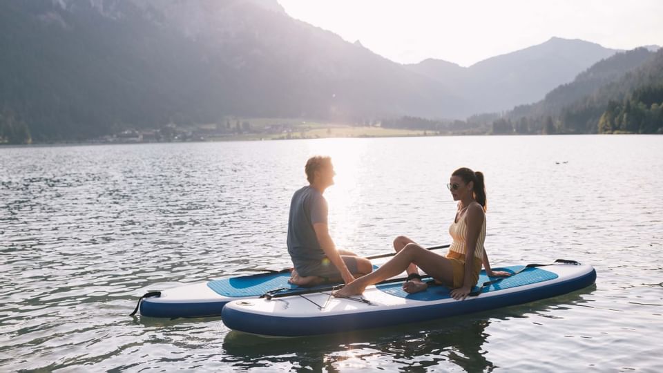 A couple on paddling boards at a lake near Liebes Rot Flueh